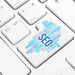 Keyboard with one key labled with a word clould of SEO terms in blue colors